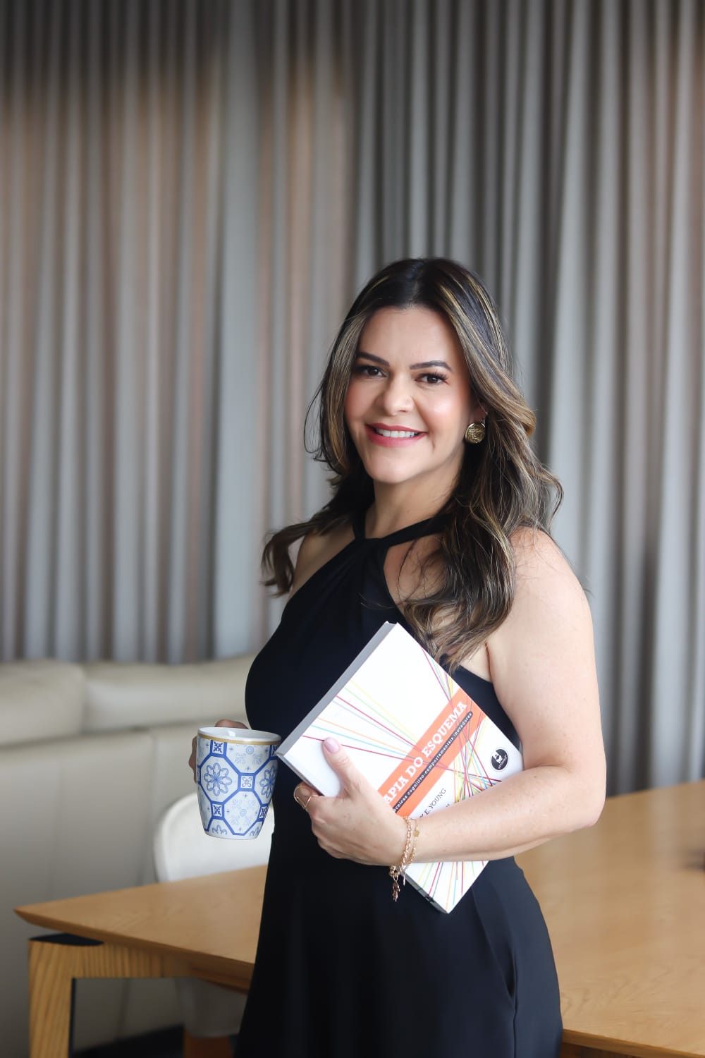Almira Marques segurando um livro de técnicas cognitivo-comportamentais